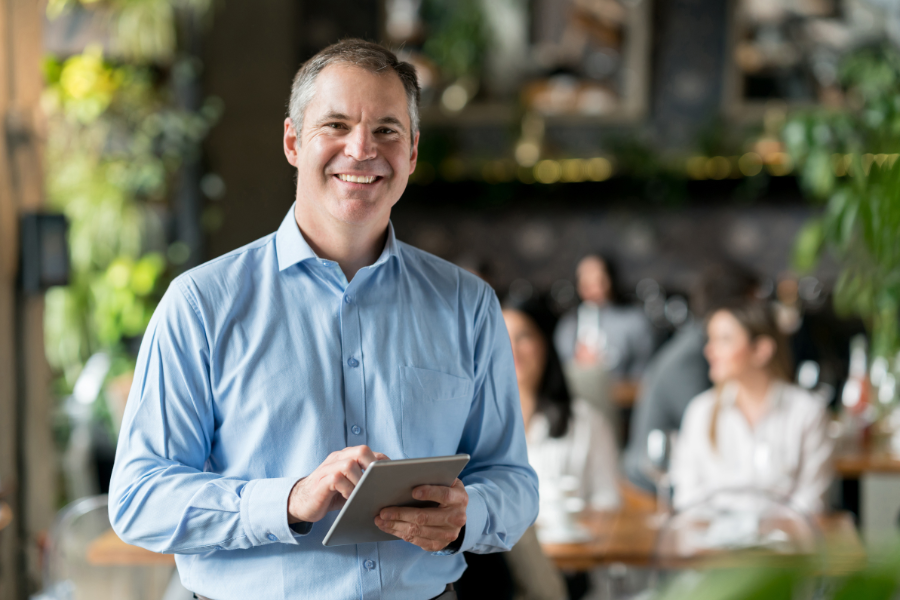 A businessman smiling because he is protected with commercial and industrial risk insurance