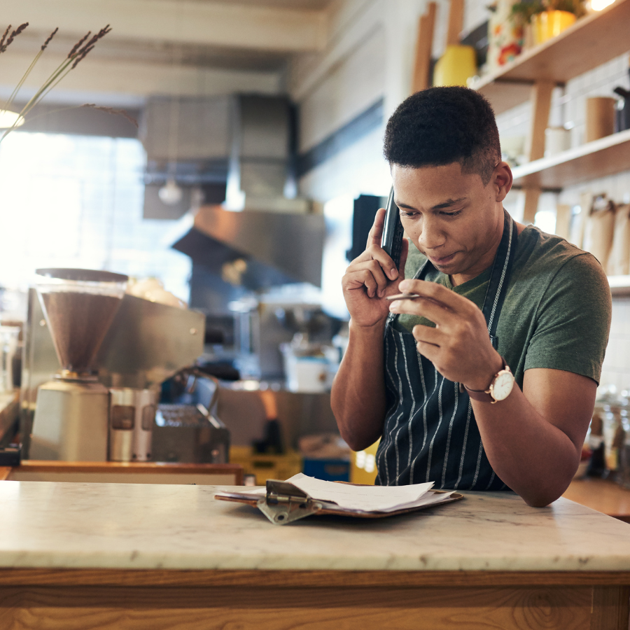 A barista on the phone at the coffee shop