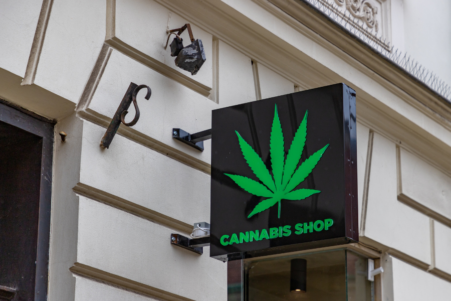 Green illuminated sign with a cannabis leaf.