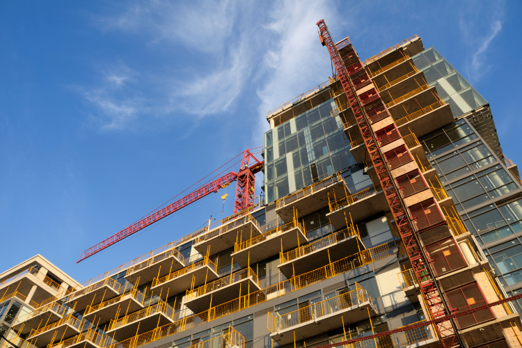 Construction site with a tall crane and partially built structure.