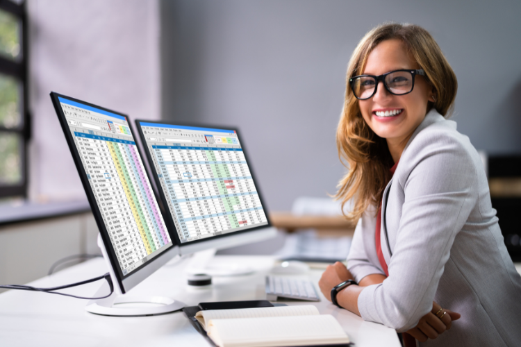 Female professional working at a computer with financial charts.